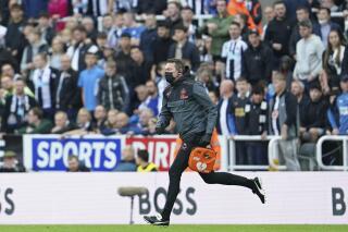A medic runs to treat someone in the crowd during an English Premier League soccer match between Newcastle and Tottenham Hotspur at St. James' Park in Newcastle, England, Sunday Oct. 17, 2021. (AP Photo/Jon Super)