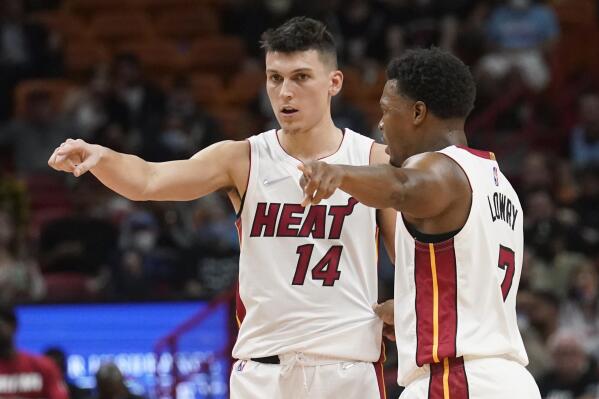 Miami Heat guards Tyler Herro (14) and Kyle Lowry (7) gesture on the court during the first half of an NBA basketball game, Monday, Oct. 25, 2021, in Miami. (AP Photo/Marta Lavandier)