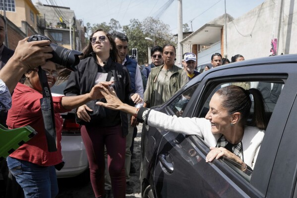 Ruling party presidential candidate Claudia Sheinbaum greets supporters as she leaves a polling station after voting in the general election in Mexico City, Sunday, June 2, 2024. (AP Photo/Eduardo Verdugo)