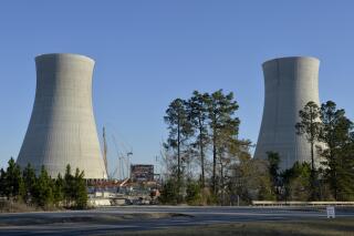 FILE - The cooling towers of the still under construction Plant Vogtle nuclear energy facility are seen, March 22, 2019 in Waynesboro, Ga. Monitors say even the most recent pushback of completion dates for two new nuclear reactors in Georgia isn't enough to account for all the delays and increased costs they see coming. Testimony filed Wednesday, Dec. 1, 2021 with the Georgia Public Service Commission by engineer Don Grace and others predict that the third reactor at Plant Vogtle near Augusta won't meet the most recent range of July 2022 to September 2022.  (Michael Holahan/The Augusta Chronicle via AP, File)