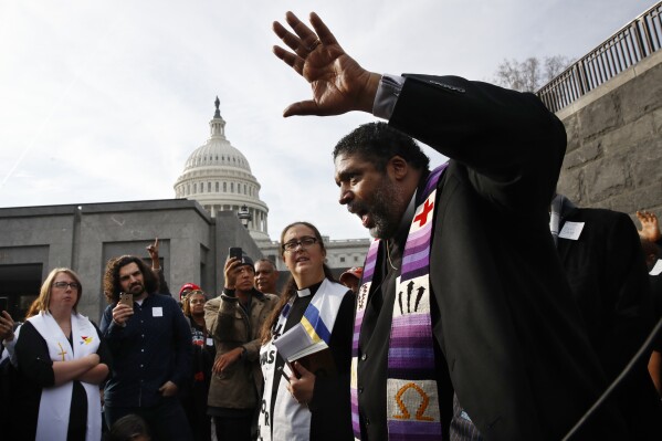 FILE - Rev. William Barber II, with the "Poor People's Campaign," speaks to the group after they prayed inside of the Capitol Rotunda in protest of the GOP tax overhaul, Monday, Dec. 4, 2017, on Capitol Hill in Washington. Barber, now director of the Center for Public Theology and Public Policy at Yale Divinity School, admires King immensely yet is critical of those who “water down the March on Washington to one man, one speech.” “That’s a political strategy to undermine the purpose of mass protest,” he says. “It must be a mass movement, not just a mass moment.” (AP Photo/Jacquelyn Martin, File)