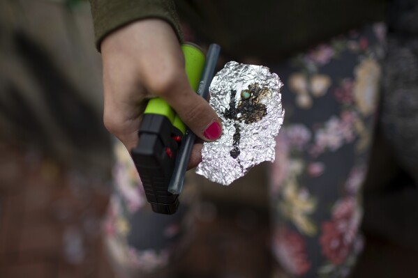 FILE - A person holds drug paraphernalia near the Washington Center building on SW Washington Street, April 4, 2023, in downtown Portland, Ore. A bill recriminalizing the possession of small amounts of drugs was passed by the Oregon Legislature, Friday, March 1, 2024, undoing a key part of the state’s first-in-the-nation drug decriminalization law as governments struggle to respond to the deadliest overdose crisis in U.S. history. (Dave Killen/The Oregonian via AP, File)