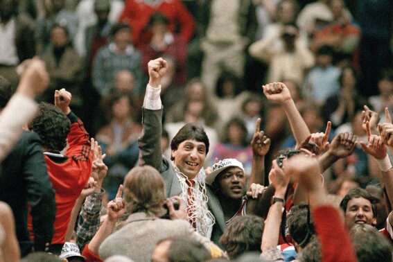 FILE - North Carolina State coach Jim Valvano, center with fist raised, celebrates after the team's win over Houston to win the NCAA men's college basketball tournament championship in Albuquerque, N.M., April 4, 1983. Ten players from North Carolina State’s 1983 national champion basketball team have sued the NCAA and the Collegiate Licensing Company seeking compensation for unauthorized use of their name, image and likeness. (AP Photo, File)