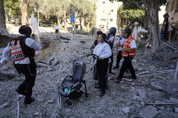 Rescue workers evacuate residents from the site where a missile launched from Iran struck in Haifa, Israel, Sunday, June 22, 2025. (AP Photo/Baz Ratner)
