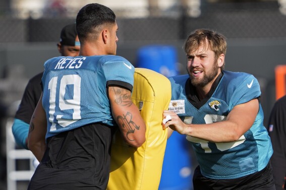 Jacksonville Jaguars tight end Josh Pederson, right, runs through a drill with tight end Samuel Reyes (19) during a practice at the NFL football team's training camp, Tuesday, Aug. 1, 2023, in Jacksonville, Fla. (AP Photo/John Raoux)