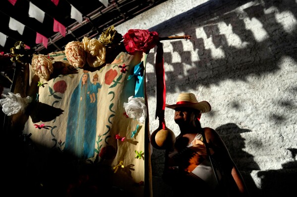 Un festejante se encuentra detrás de la bandera de Nuestra Señora del Rosario en la Fiesta de las Cavalhadas, o del Espíritu Santo, en Pirenópolis, estado de Goiás, Brasil, el domingo 8 de junio de 2025. (Foto AP/Eraldo Peres)