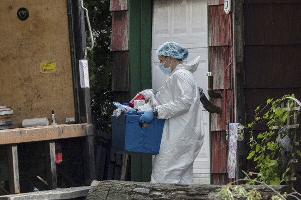 A crime laboratory officer removes a box of items as law enforcement searches the home of Rex Heuermann, Saturday, July 15, 2023, in Massapequa Park, N.Y. Heuermann, a Long Island architect, was charged Friday, July 14, with murder in the deaths of three of the 11 victims in a long-unsolved string of killings known as the Gilgo Beach murders. (AP Photo/Jeenah Moon)