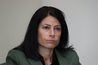 In this June 4, 2019, photo, Dana Nessel, Attorney General of Michigan, listens to a question from reporters in Detroit. Hundreds of boxes. Millions of records. From Texas to Michigan this month, attorneys general are sifting through "secret" files, nondisclosure agreements between the church and families, heart wrenching letters from parents begging for action, priests' own psychiatric evaluations. They're looking to prosecute, and not just priests. (AP Photo/Paul Sancya)