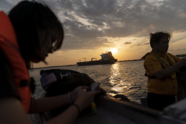 A foreign tanker ship sails through Serangoon Harbor between Malaysia and Singapore as workers from the Eco-Ark floating fish farm return to shore in Singapore, Tuesday, July 18, 2023. Singapore, a small city-state of 6 million with nearly no natural resources, must import clean energy to meet its renewable energy goals. Singapore aims to achieve net-zero carbon emissions by 2050. (AP Photo/David Goldman)