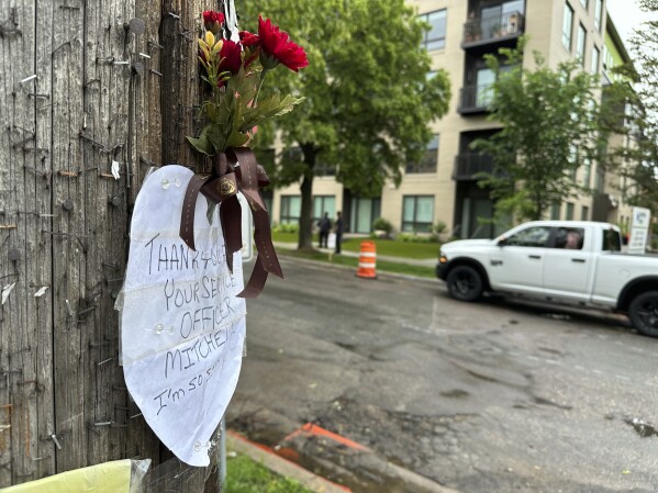 A small tribute marked the scene of a shooting the day prior where at least three people were killed, including a police officer, Friday, May 31, 2024 in Minneapolis. Officer Jamal Mitchell responding to a shooting call was ambushed and killed Thursday when he stopped to provide aid to a man who appeared to be a victim. That man instead wound up shooting the officer, authorities said.(AP Photo/ Mark Vancleave)