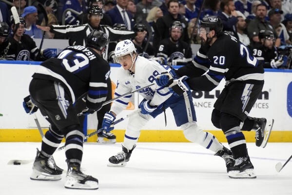 Toronto Maple Leafs right wing William Nylander (88) gets between Tampa Bay Lightning left wing Nick Paul (20) and defenseman Darren Raddysh (43) during the third period of an NHL hockey game Wednesday, April 17, 2024, in Tampa, Fla. (AP Photo/Chris O'Meara)