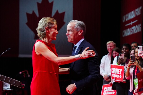 Canadian Prime Minister Mark Carney reacts with wife Diana Fox Carney on stage at his campaign headquarters after the Liberal Party won the Canadian election in Ottawa on Tuesday, April 29, 2025. (Sean Kilpatrick/The Canadian Press via AP)