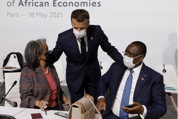 FILE - French President Emmanuel Macron, center, salutes Ethiopia's President Sahle-Work Zewde, left, and Senegal's President Macky Sall at the Summit on the Financing of African Economies on May 18, 2021 in Paris. European Union leaders want to re-engage with African nations and counter the growing influence from China and Russia across the continent during a two-day summit in Brussels.The EU-African Union gathering starting Thursday, Feb. 17, 2022, was initially planned for 2020 but was postponed due to the coronavirus pandemic and agenda issues. So it's the first time EU and African Union leaders meet in that format since 2017.  (Photo by Ludovic Marin, Pool via AP)