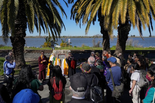 Buddhist faith leaders and community members gather at the Birthplace of Antioch marker during the "May We Gather" pilgrimage, Saturday, March 16, 2024, in Antioch, Calif. The event aimed to use karmic cleansing through chants, prayer and testimony to heal racial trauma caused by anti-Chinese discrimination in Antioch in the 1870s. (AP Photo/Godofredo A. Vasquez)