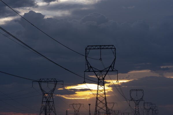 As the sun rises behind powerlines on Thursday, Aug. 22, 2024, in Boardman, Ore. (AP Photo/Jenny Kane)