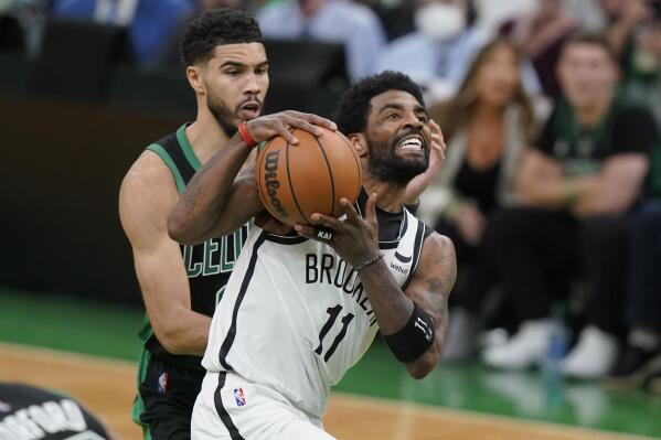 Brooklyn Nets guard Kyrie Irving (11) drives toward the basket as Boston Celtics forward Jayson Tatum (0) defends in the second half of Game 1 of an NBA basketball first-round Eastern Conference playoff series, Sunday, April 17, 2022, in Boston. The Celtics won 115-114. (AP Photo/Steven Senne)