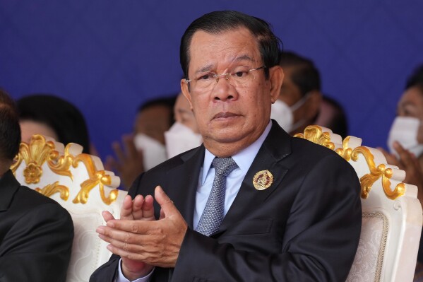 FILE - Cambodian Prime Minister Hun Sen claps during the 71st anniversary celebration of the Cambodian People's Party (CPP) at its headquarters in Phnom Penh, Cambodia, Tuesday, June 28, 2022. Cambodia’s long-serving leader says his government will amend the country’s election law to bar anyone who fails to vote from standing as a candidate in future elections, in what would be the latest marginalization of his political foes. (AP Photo/Heng Sinith, File)