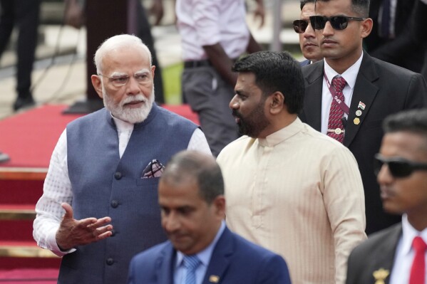 Indian Prime Minister Narendra Modi, left, and Sri Lankan president Anura Kumara Dissanayake, center right, walk together during an official welcome ceremony in Colombo, Sri Lanka, Saturday, April 5, 2025. (AP Photo/Eranga Jayawardena)