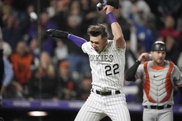 Colorado Rockies' Nolan Jones celebrates after scoring the winning run on a throwing error by San Francisco Giants left fielder Mike Yastrzemski during the ninth inning of a baseball game Friday, Sept. 15, 2023, in Denver. Giants catcher Patrick Bailey is at right. (AP Photo/David Zalubowski)