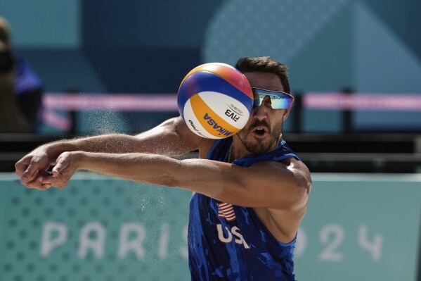 US' Miles Evans hits the ball during the men's round of 16 beach volleyball match between USA and Norway at Eiffel Tower Stadium at the 2024 Summer Olympics, Monday, Aug. 5, 2024, in Paris, France. (AP Photo/Louise Delmotte)