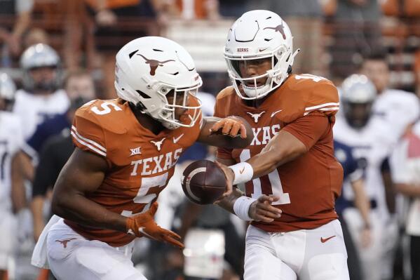 Texas quarterback Casey Thompson (11) hands the ball off to Bijan Robinson (5) during the first half of the team's NCAA college football game against Rice on Saturday, Sept. 18, 2021, in Austin, Texas. (AP Photo/Chuck Burton)