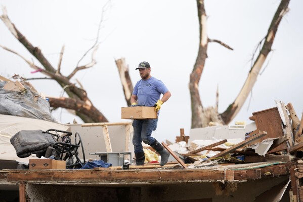 Un hombre busca entre los restos de una casa dañada por un tornado el martes 21 de mayo de 2024 en Greenfield, Iowa. (AP Foto/Charlie Neibergall)