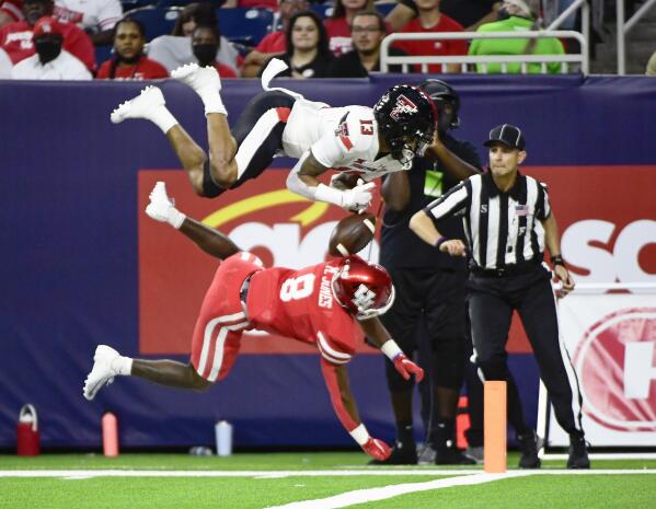 Texas Tech wide receiver Erik Ezukanma (13) is knocked out of bounds by Houston cornerback Marcus Jones (8) during the first half of an NCAA college football game Saturday, Sept. 4, 2021, in Houston. (AP Photo/Justin Rex)
