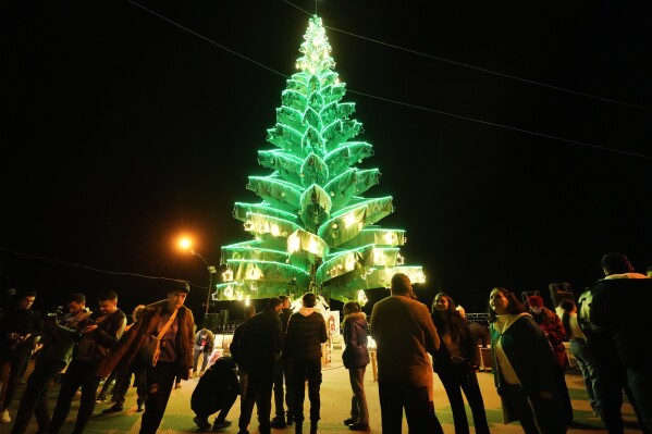 Syrian citizens gather outside Saydnaya Convent during the lighting of the Christmas tree, in Saydnaya town on the outskirts of Damascus, Syria, Tuesday, Dec. 24, 2024. (AP Photo/Hussein Malla)