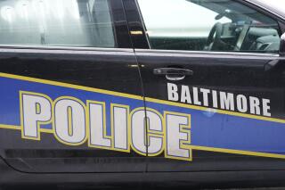 FILE - A Baltimore police cruiser is seen outside of a building as officers check on a call, Feb. 18, 2021, in Baltimore. Baltimore leaders agreed Wednesday, March 1, 2023 to a $6 million settlement agreement in the case of a driver who was killed during a 2010 police chase involving Gun Trace Task Force officers, marking the city’s latest payout resulting from flagrant misconduct inside the rogue law enforcement unit. (AP Photo/Julio Cortez, file)