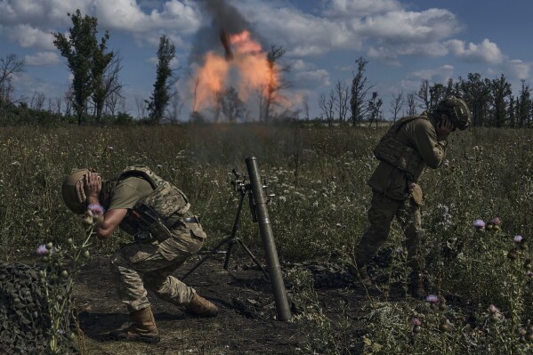 Ukrainian soldiers fire a mortar towards Russian positions at the front line, near Bakhmut, Donetsk region, Ukraine, Saturday, Aug. 12 2023. (AP photo/Libkos)