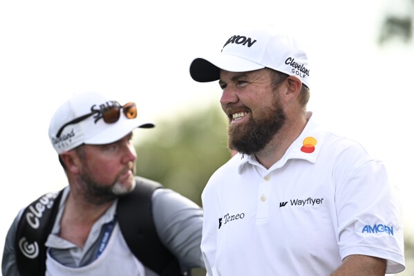 Shane Lowry, right, of Ireland, walks on the 11th fairway after hitting his tee shot during the first round of the Arnold Palmer Invitational golf tournament, Thursday, March 7, 2024, in Orlando, Fla. (AP Photo/Phelan M. Ebenhack)
