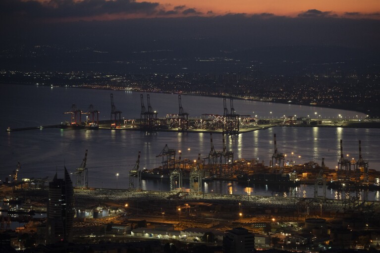 FILE - Gantry cranes used to load and unload cargo containers from ships sit stand during the dawn, in the port of Haifa, Israel, on Aug. 15, 2024. (AP Photo/Leo Correa, File)