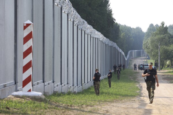 FILE - Polish border guards patrol the area of a newly built metal wall on the border between Poland and Belarus, near Kuznice, Poland, on June 30, 2022. Polish and Lithuanian leaders held an urgent meeting Thursday Aug. 3, 2023 in a strategically sensitive area where their NATO nations border Belarus and the Russian territory of Kaliningrad, warning that they are bracing for provocations from Moscow and Minsk in the area. (AP Photo/Michal Dyjuk, File)