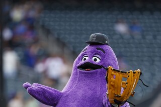 FILE - McDonald's character Grimace throws out a ceremonial first pitch before a baseball game between the Miami Marlins and the New York Mets, June 12, 2024, in New York. (AP Photo/Rich Schultz, File)
