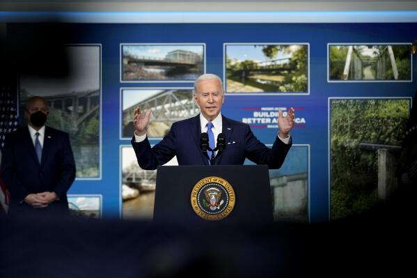 President Joe Biden speaks about the Bipartisan Infrastructure Law at the South Court Auditorium in the Eisenhower Executive Office Building on the White House Campus in Washington, Friday, Jan. 14, 2022, as Mitch Landrieu, Senior Advisor & Infrastructure Act Implementation Coordinator, looks on. (AP Photo/Andrew Harnik)