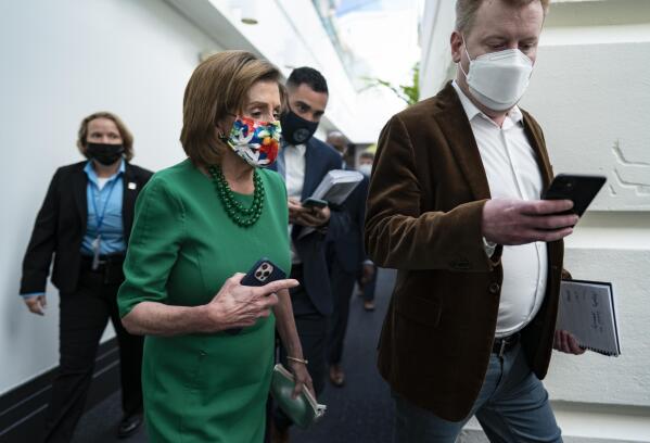 Speaker of the House Nancy Pelosi, D-Calif., is accompanied by staff and security as she rushes to a Democratic Caucus meeting as work continues on President Joe Biden's sweeping domestic agenda, the Build Back Better Act, at the Capitol in Washington, Wednesday, Nov. 3, 2021. (AP Photo/J. Scott Applewhite)