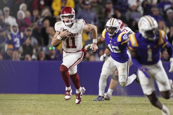 Oklahoma quarterback Jackson Arnold (11) carries past LSU linebacker Davhon Keys (42) in the second half an NCAA college football game in Baton Rouge, La., Saturday, Nov. 30, 2024. LSU won 37-17. (AP Photo/Gerald Herbert)