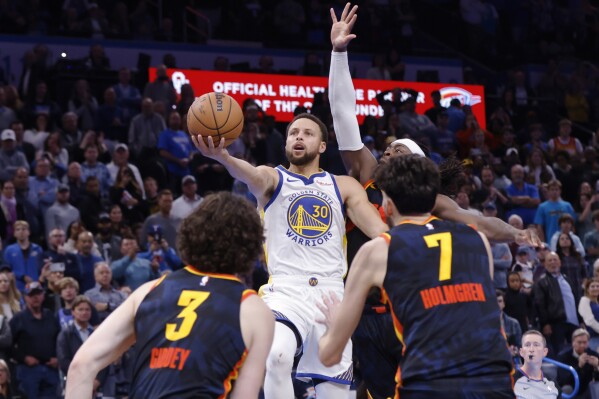 Golden State Warriors guard Stephen Curry (30) prepares to shoot, scoring the winning basket in the final second, as Oklahoma City Thunder guard Josh Giddey (3), forward Chet Holmgren (7) and guard Luguentz Dort, back right, defend during an NBA in-season tournament basketball game Friday, Nov. 3, 2023, in Oklahoma City. (AP Photo/Nate Billings)