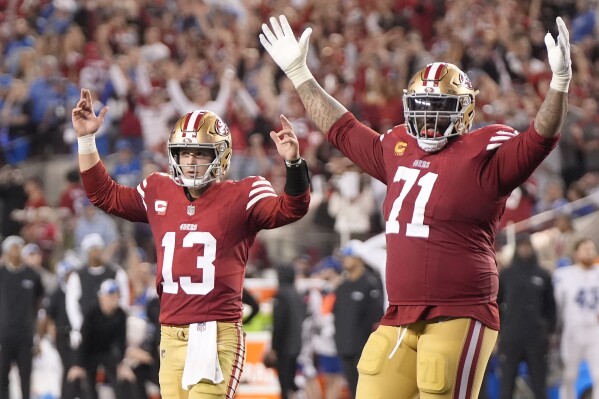 San Francisco 49ers quarterback Brock Purdy (13) and offensive tackle Trent Williams (71) celebrate after a touchdown run by Elijah Mitchell during the second half of the NFC Championship NFL football game against the Detroit Lions in Santa Clara, Calif., Sunday, Jan. 28, 2024. (AP Photo/Mark J. Terrill)