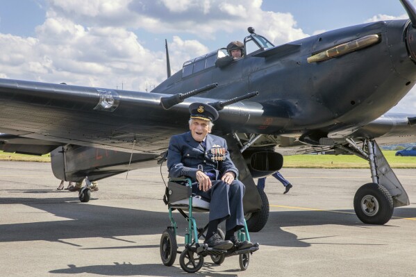 In this photo provided by the UK Ministry of Defence on Tuesday, March 18, 2025, John "Paddy" Hemingway, the last surviving pilot of the iconic Battle of Britain, poses for a photo in front of a Hurricane on July 22, 2022. (UK MOD via AP)
