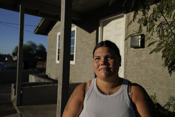 Bridget Ibarra, sits outside her Chandler home Friday, June 16, 2023. By the time her daughter Aaliyah started second grade, her family had moved five times in four years in search of stable housing. As she was about to start a new school, Bridget, saw how much it was affecting her education (AP Photo/Darryl Webb)