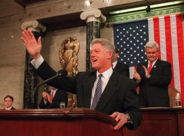 President Clinton waves from the podium before beginning his State of the Union address before a joint meeting of Congress at the Capitol on Tuesday Feb. 4, 1997, as Speaker of the House Newt Gingrich claps from behind. (AP Photo/ Joe Marquette, POOL)