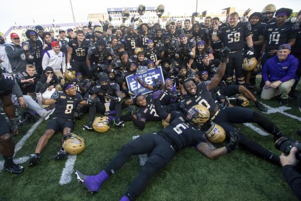 James Madison players gather for a group photo as they celebrate after an NCAA college football game against Coastal Carolina in Harrisonburg, Va., Saturday, Nov. 26, 2022. (Daniel Lin/Daily News-Record via AP)