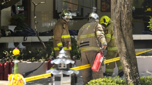 Firefighters investigate an explosion site at a school in Bangkok, Thailand, Friday, June 23, 2023. A fire extinguisher exploded during a high school's annual fire drill Friday in Thailand's capital. (AP Photo/Sakchai Lalit)