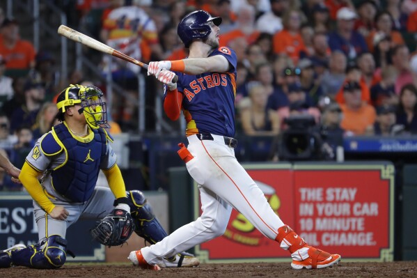 Houston Astros' Kyle Tucker, right, watches his three-run home run in front of Milwaukee Brewers catcher William Contreras, left, during the seventh inning of a baseball game Sunday, May 19, 2024, in Houston. (AP Photo/Michael Wyke)