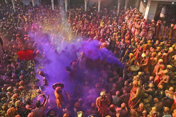 Villagers from Barsana and Nandgaon smeared with colors play Lathmar Holi at Nandagram temple in Nandgoan village, 115 kilometers (70 miles) south of New Delhi, India, Tuesday, March 19, 2024. (AP Photo/Kabir Jhangiani)