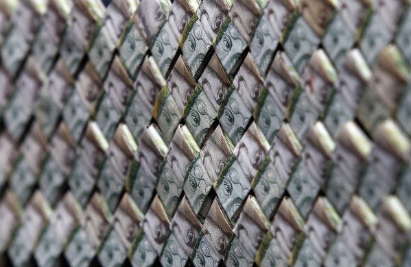 
              In this Feb. 22, 2018 photo, Venezuelan Bolivars weaved together create a purse that is for sale in La Parada, Colombia, on the border with Venezuela. A family of Venezuelan immigrants to Colombia are repurposing their worthless bolivars into origami-made paper wallets, belts and even purses as the currency plunges further in value amid four-digit inflation. (AP Photo/Fernando Vergara)
            