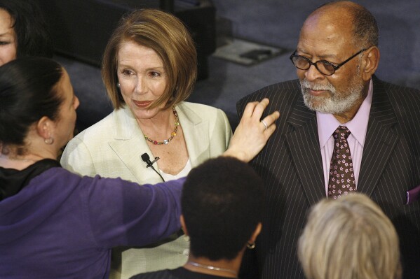 FILE - House Speaker Nancy Pelosi, center, and Reverend Cecil Williams, right, meet some of the church members at Glide Memorial United Methodist Church in San Francisco, March 28, 2010. Williams, who with his late wife turned Glide Church in San Francisco into a world-renowned haven for poor, homeless, and marginalized people, died Monday, April 22, 2024, at his home in San Francisco. He was 94. (AP Photo/Tony Avelar,File)