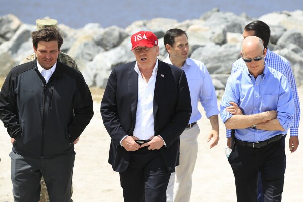 
              President Donald Trump walks with, from left, Florida Gov. Ron DeSantis, Sen. Marco Rubio, R-Fla., and Sen. Rick Scott, R-Fla., during a visit to Lake Okeechobee and Herbert Hoover Dike at Canal Point, Fla., Friday, March 29, 2019. (AP Photo/Manuel Balce Ceneta)
            