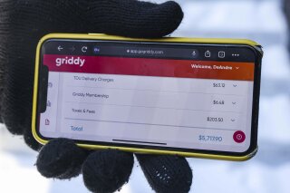 DeAndré Upshaw shows a $5,000 bill from Griddy on his cell phone for his 900-square-foot apartment during very cold weather in Dallas, on Friday, Feb. 19, 2021. The Texas power supplier Griddy, which sells unusual plans with prices tied to the spot price of power on the Texas grid, warned its customers over the weekend that their bills would rise significantly during the storm and that they should switch providers. (Lola Gomez//The Dallas Morning News via AP)
